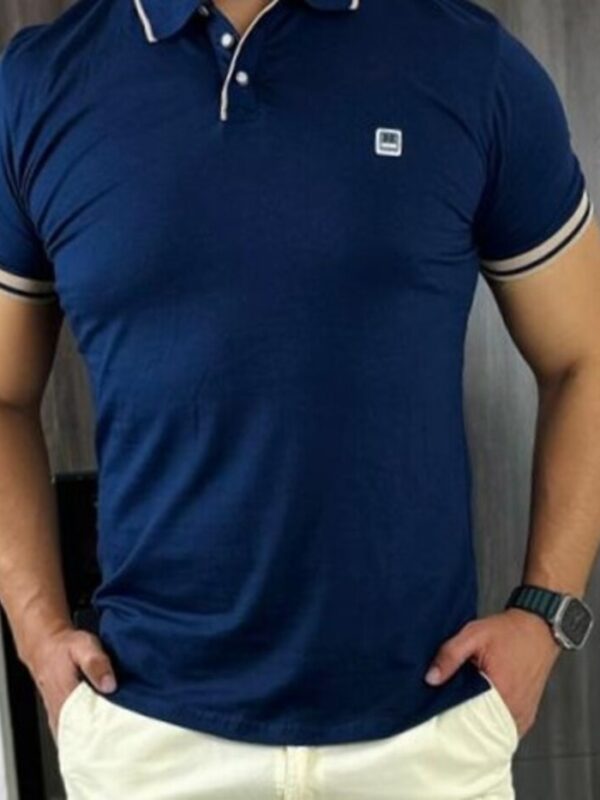 hombre moreno con camiseta azul oscuro, pantalon y reloj